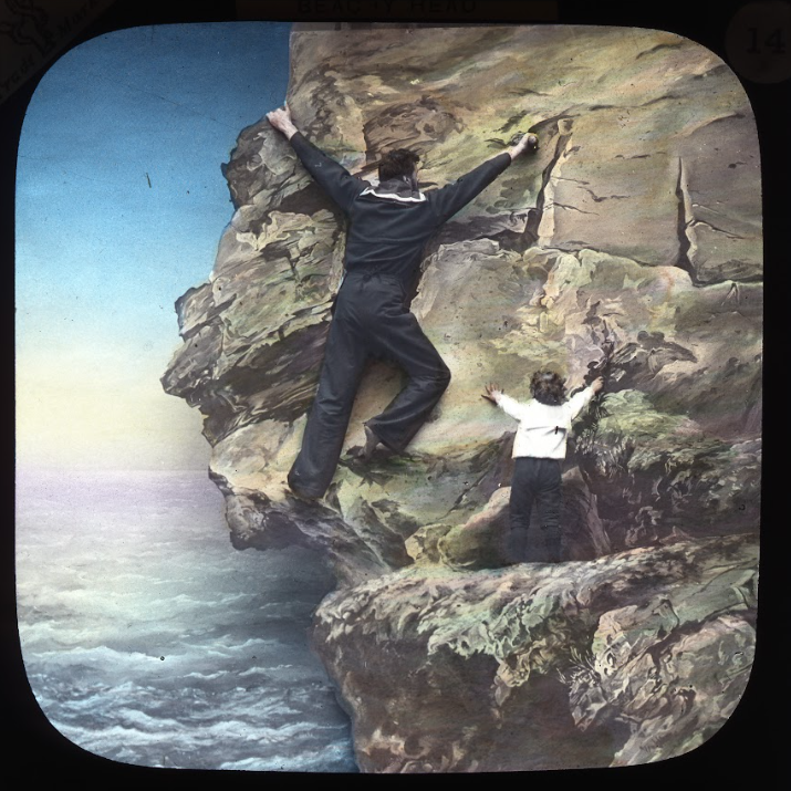 man climbing with son on rocks