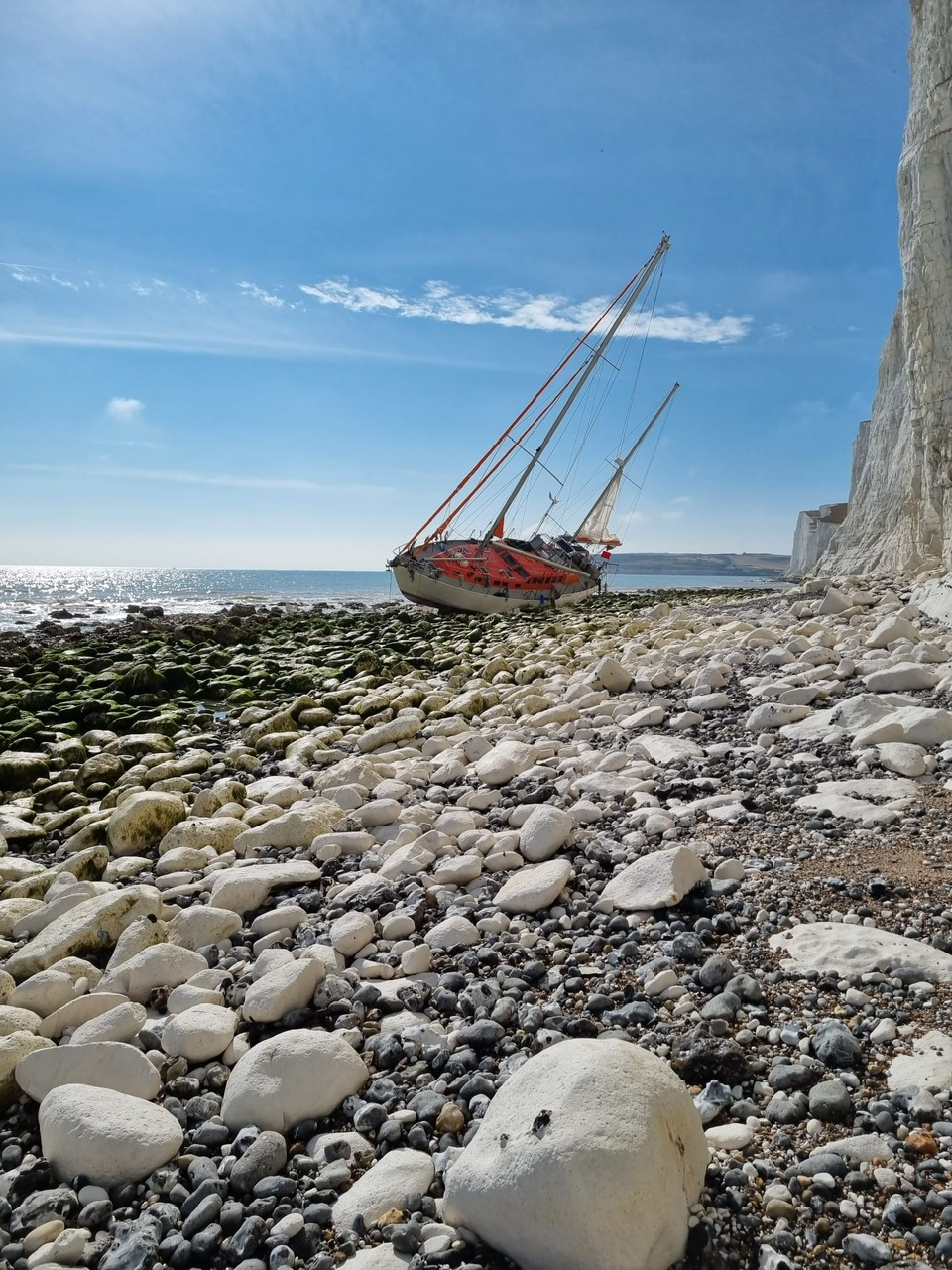Vessel aground and out of water under chalk cliff
