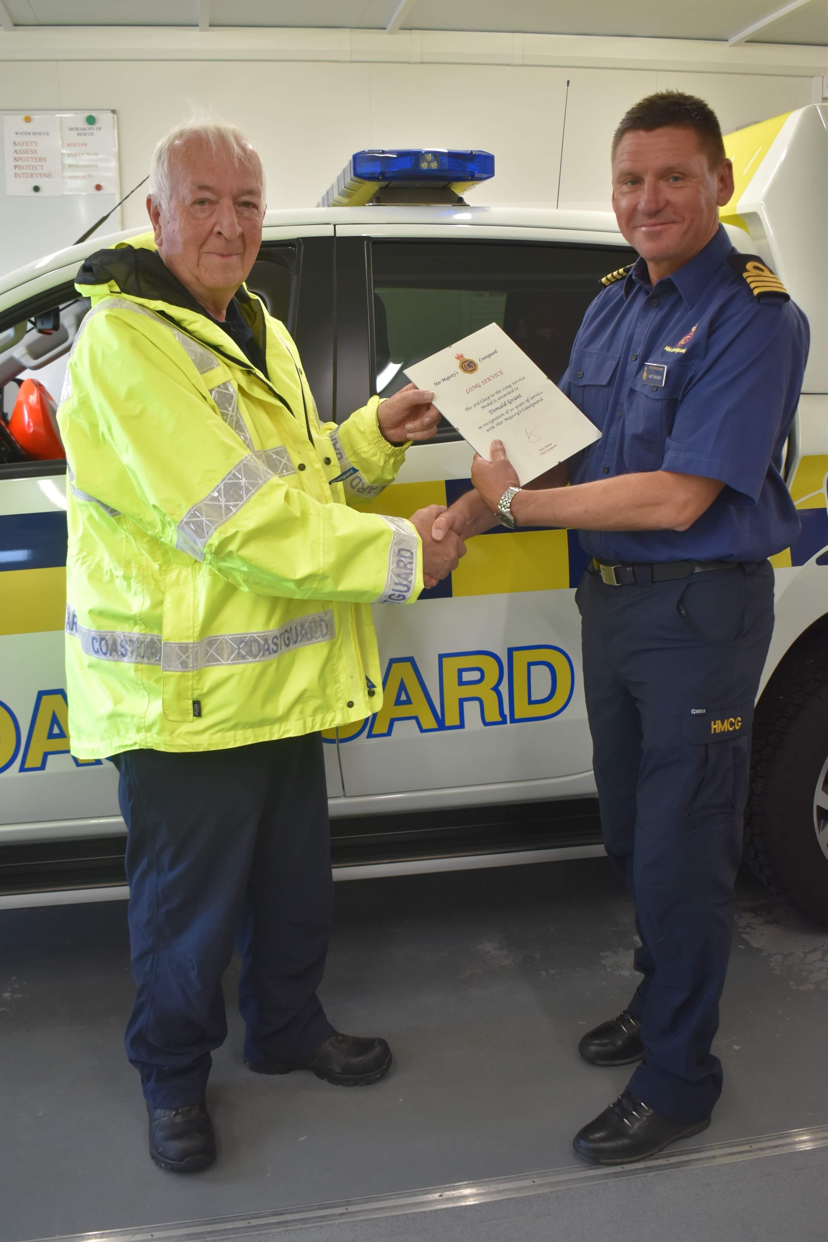 Donald Grant (left) receives his certificate from Divisional Commander Matt MacKay