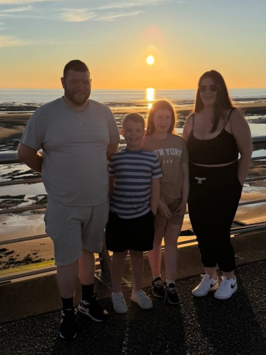 Damon, Clayton, Faye and Dannie Garforth by a beach as the sun sets over the sea behind them