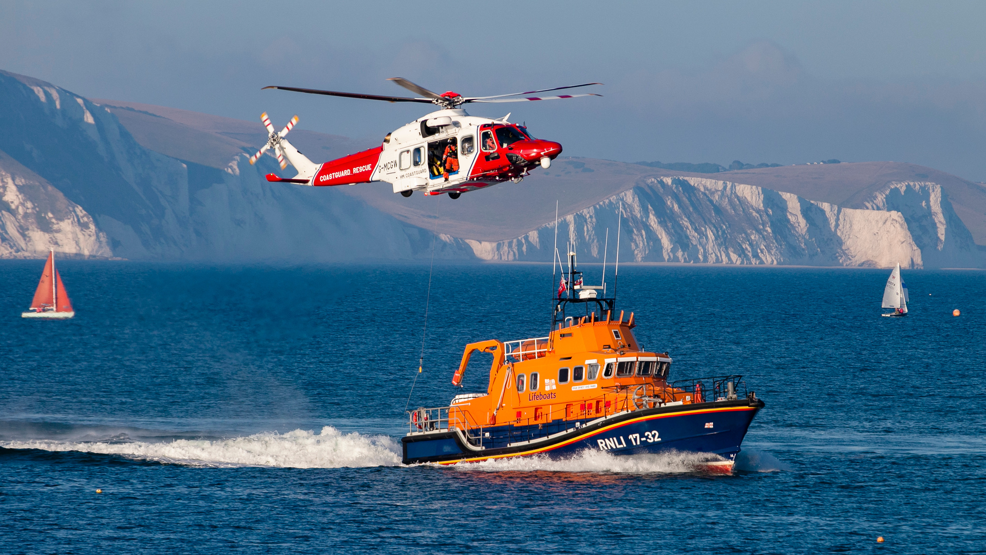 HM Coastguard helicopter hovering above an RNLI all-weather lifeboat