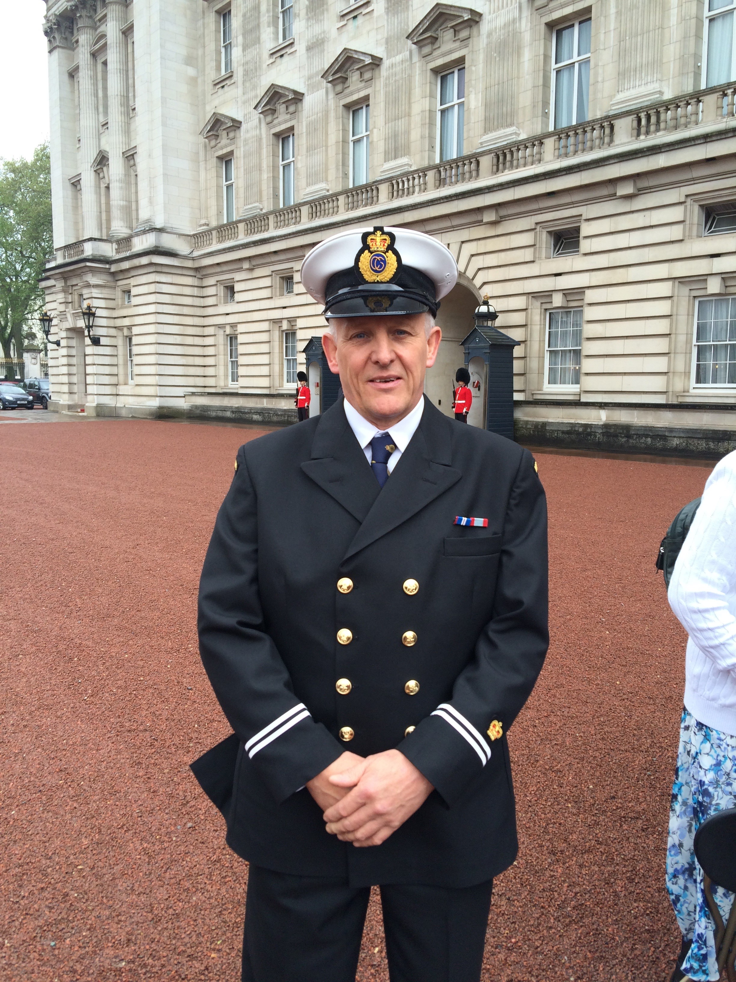 Male Coastguard in dress uniform poses in front of Buckingham Palace