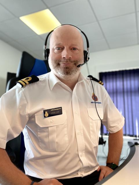 Maritime call handler in uniform faces camera with headset on