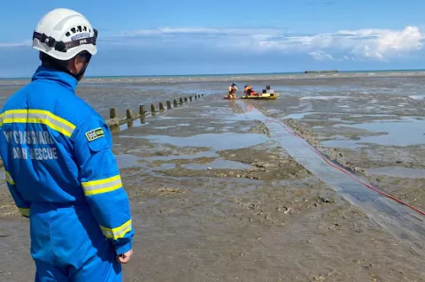 A coastguard rescue officer looks on as the mud rescue takes place