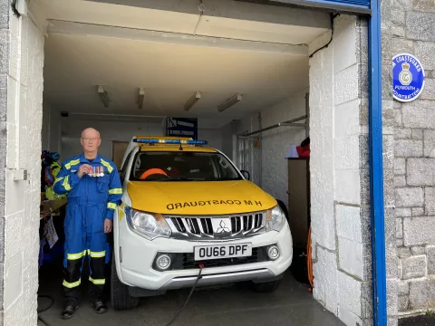 Keith poses with his service medals alongside the current, electric response vehicle in the station he has called 'home' for 56-years