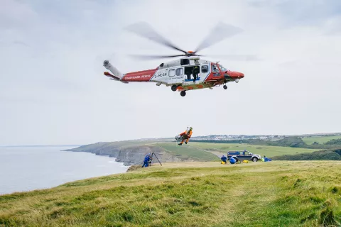 A HM Coastguard AW189 helicopter in a training exercise along the coast.