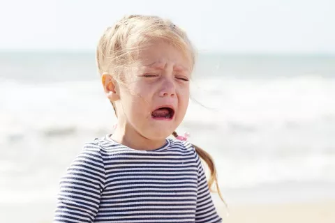 Girl crying on the beach. Picture credit: Shutterstock