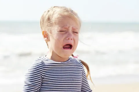 Girl crying on the beach. Picture credit: Shutterstock