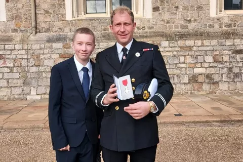Daniel Thomson received his MBE supported by 12 year-old son Jacob