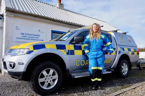 Coastguard rescue officer Kate Hannett next to a coastguard vehicle.