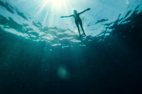 Float to live - a swimmer in the water with their arms spread out