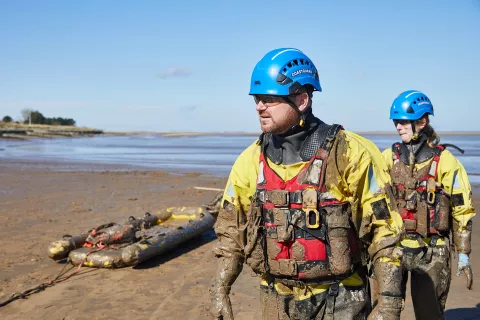 Two members of a coastguard mud rescue team 