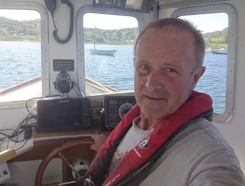 Hans Unkles behind the wheel of his electric fishing vessel, Lorna Jane