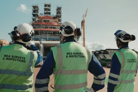A three-person survey and inspection team at work on a vessel