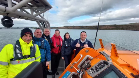 Deputy to the SOSREP Lisa McAuliffe standing with coastguard colleagues onboard a vessel