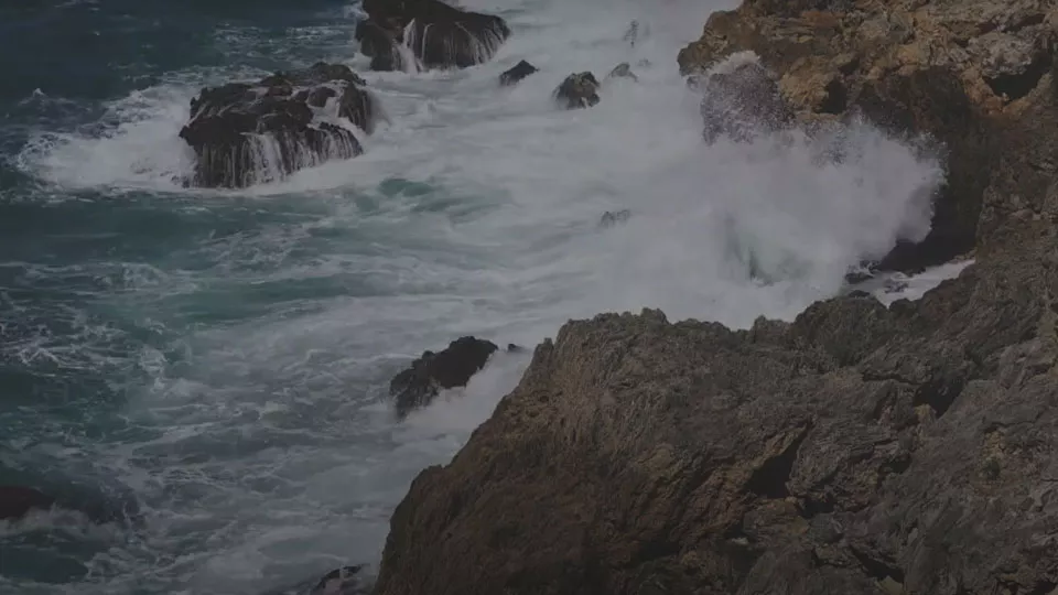 Waves crash against rocks along the UK coastline