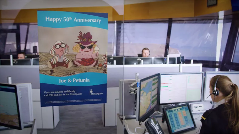 A poster with the words "happy 50th anniversary Joe and Petunia" hangs in a HM Coastguard Operations Centre