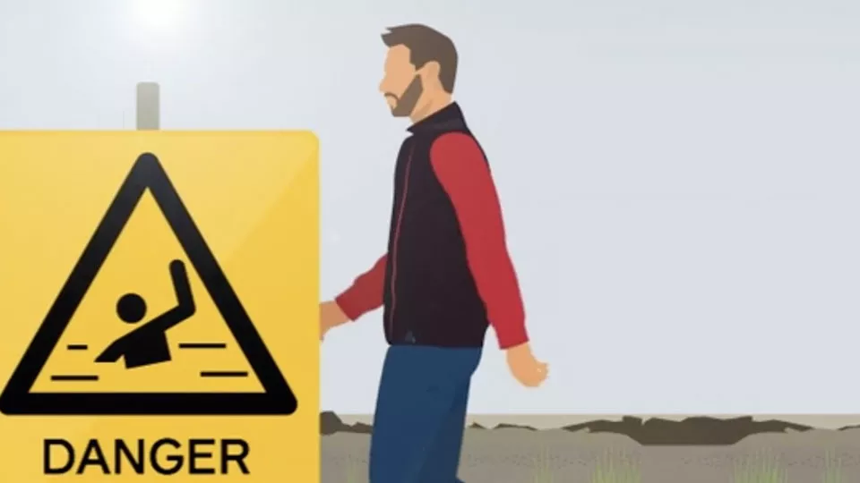 Animated image showing a man walking in front of a warning sign