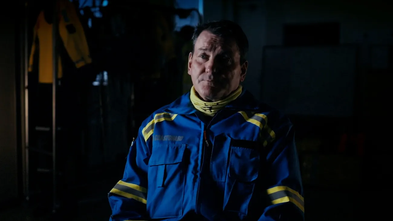 A Coastguard Rescue Officer sits facing the camera