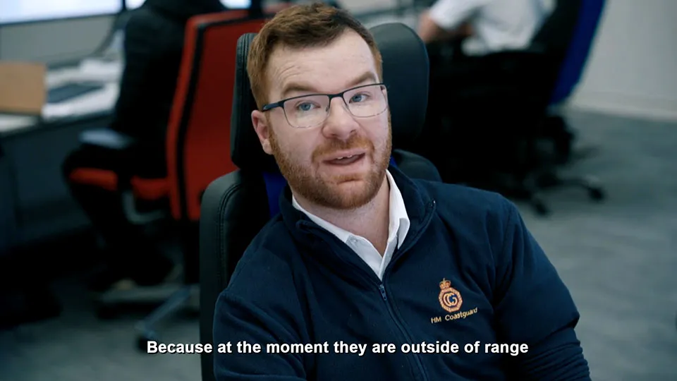 A man wearing a HM Coastguard fleece is talking to the camera