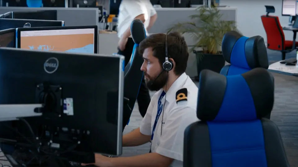 A male Coastguard in a HM Coastguard operations room