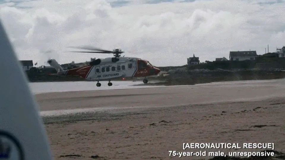 A HM Coastguard helicopter hovers over a beach