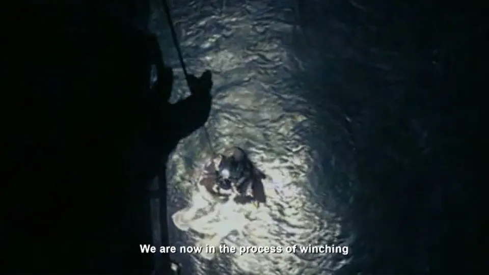 View from an HM Coastguard search and rescue helicopter looking down as someone is being winched towards the sea