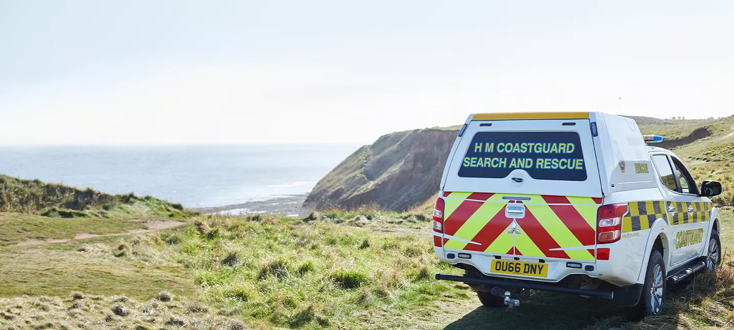 Coastguard van at a cliff with the sea in the distance