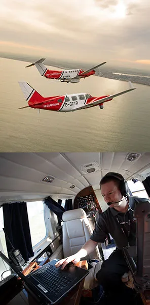 Two fixed wing air craft flying at sunset and a crew member inside the aircraft