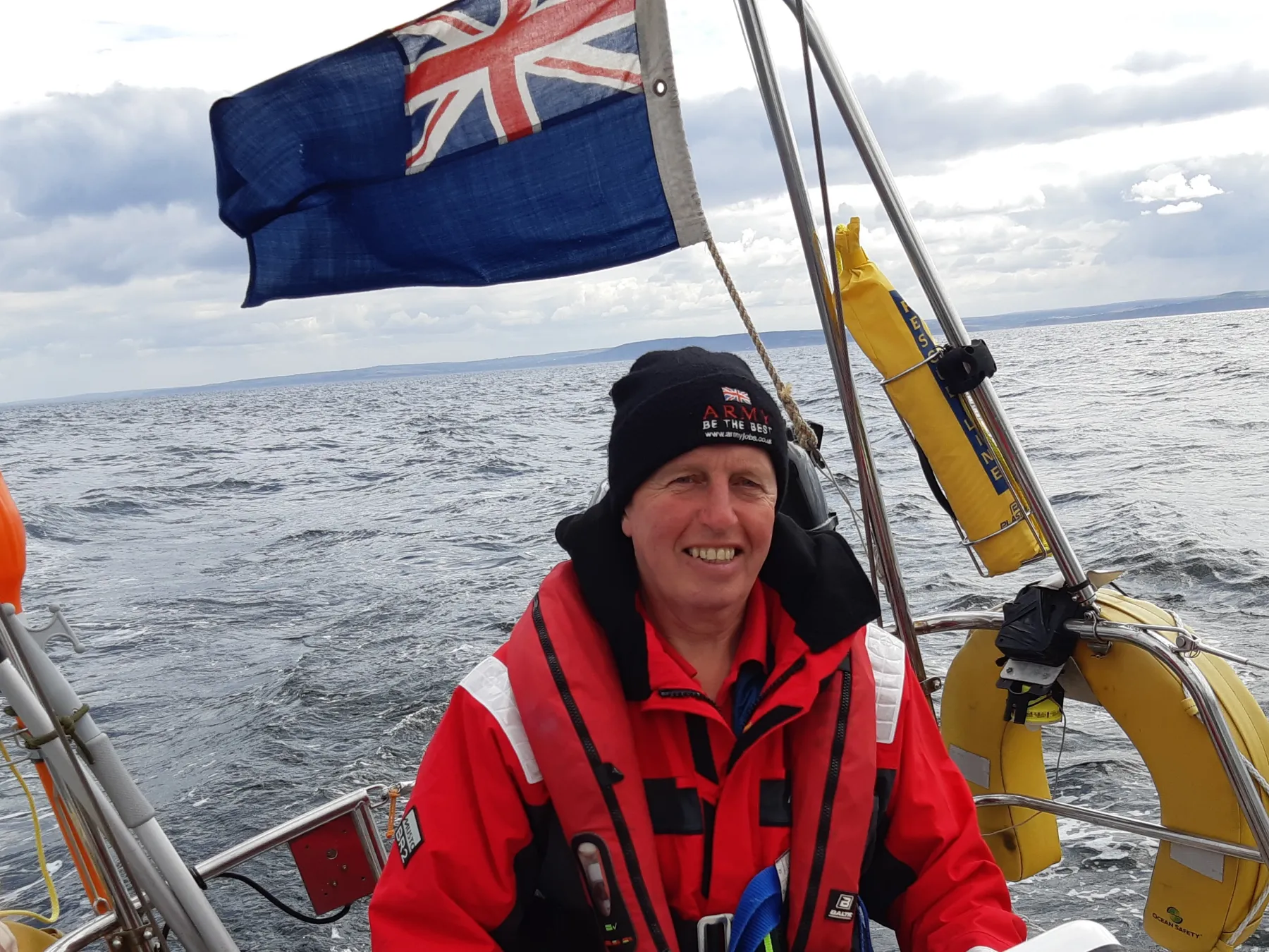 David Fuller in red at helm of vessel