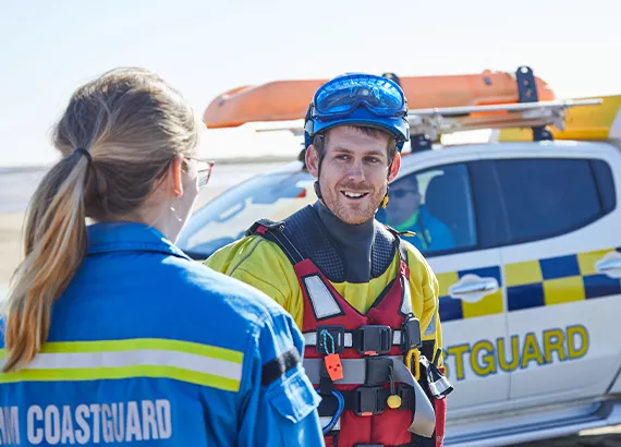 Tom Birchall talking to a Coastguard Rescue Officer in front of a coastguard rescue vehicle
