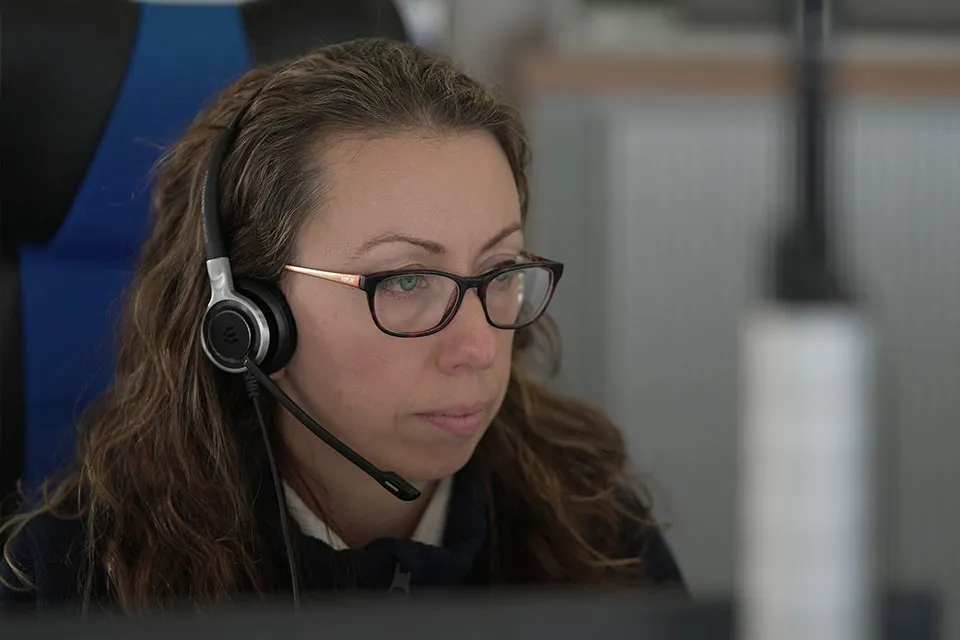 A woman wearing a headset in a maritime operations centre