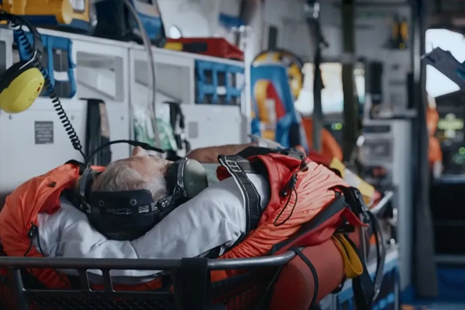 A man lies on a stretcher inside the HM Coastguard rescue helicopter