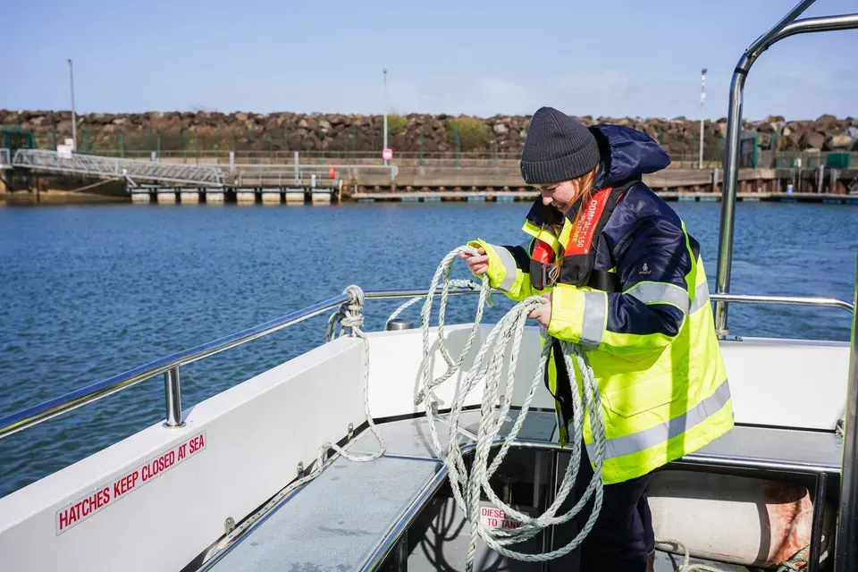 A woman onboard a vessel wearing a personal flotation device