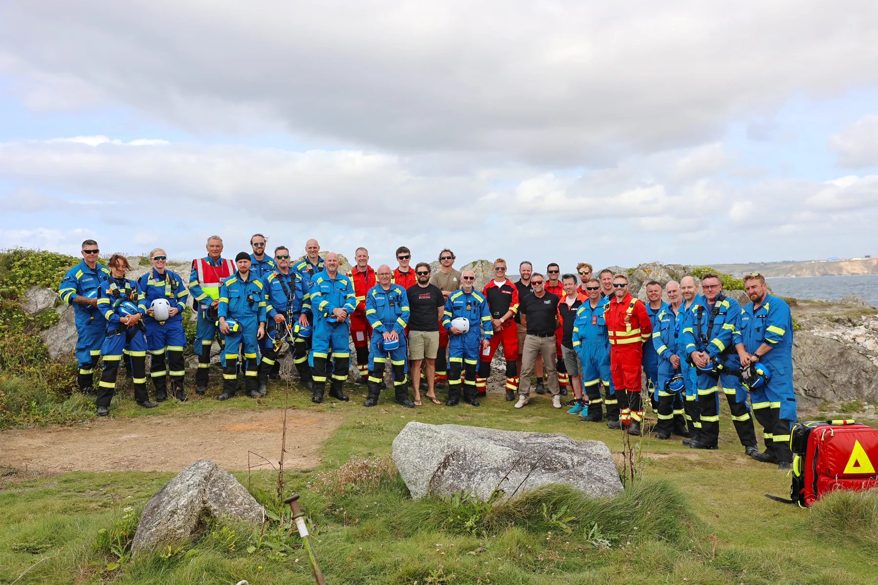 A group photo by the cliff of Coastguard Rescue Officers and Cornwall Air Ambulance personnel