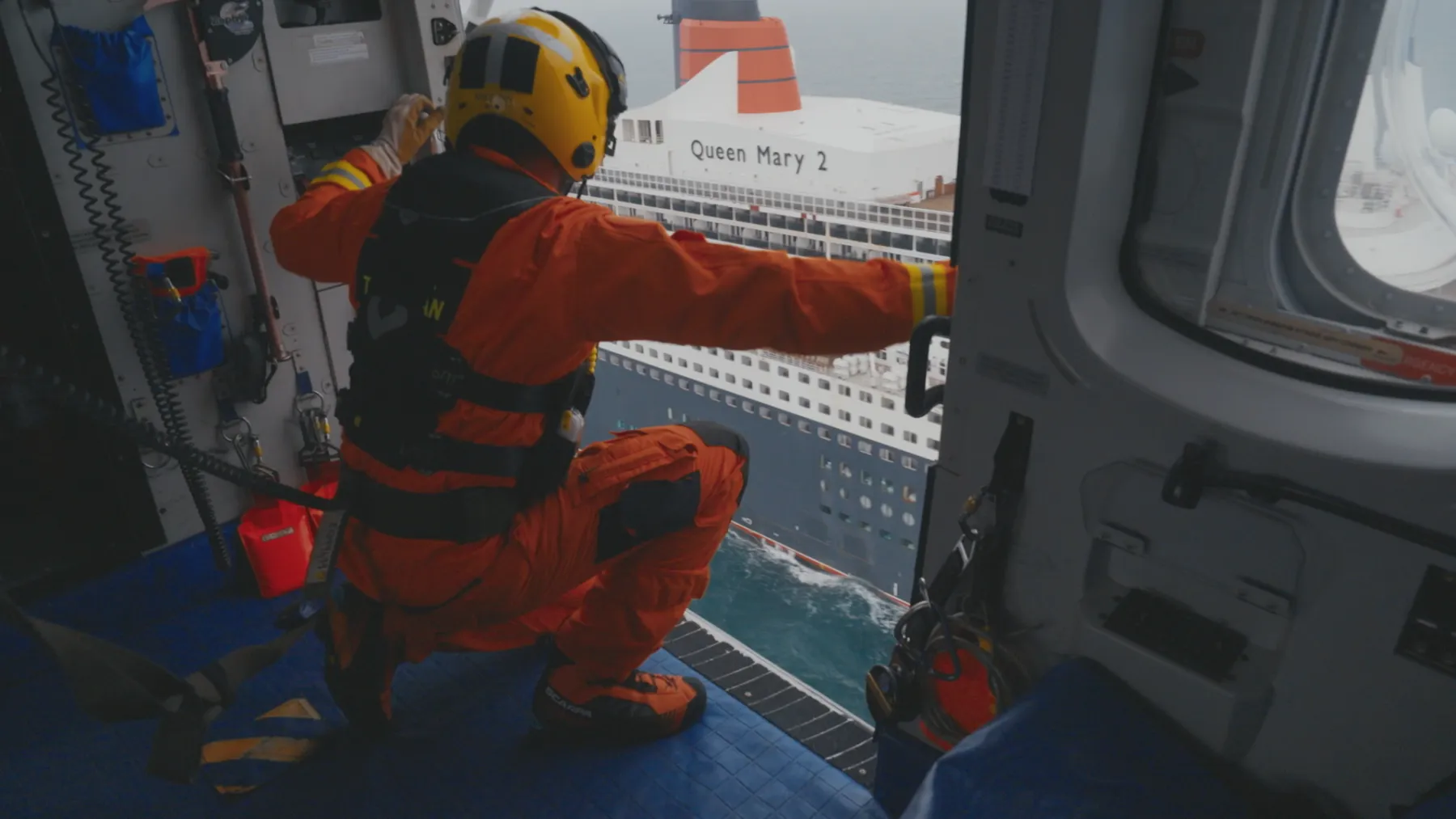 An HM Coastguard Rescue Helicopter surveys the Queen Mary 2 cruise ship 