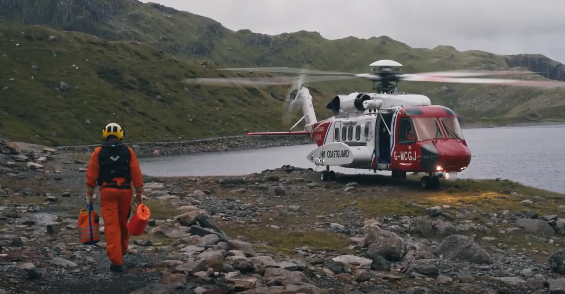An HM Coastguard search and rescue helicopter on rocky terrain