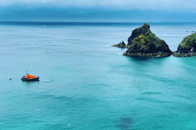 Mullion Coastguard Rescue Team and the RNLI helping when three people on a dinghy were struggling with the tide and offshore winds.