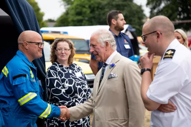 King Charles shaking hands with members of the Coastguard during a visit to Devon as part of the Coastguard 200 celebrations