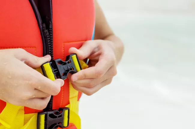 Close up of an individual fastening their lifejacket