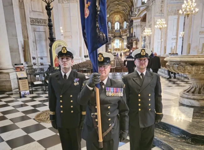 From left standing to attention at St Paul's Cathedral are Dan Foster, Kevin Moran holding the HM Coastguard colours, and George Belcher