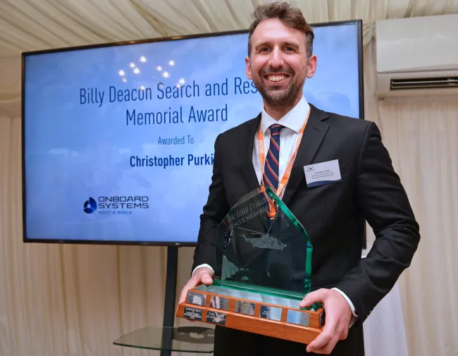 Chris Purkiss, a Winch Paramedic from Lydd’s R163 Coastguard Rescue Helicopter team, received the Billy Deacon SAR Memorial Trophy at the House of Commons as part of the Air League’s Annual Reception Ceremony on 9 July. 