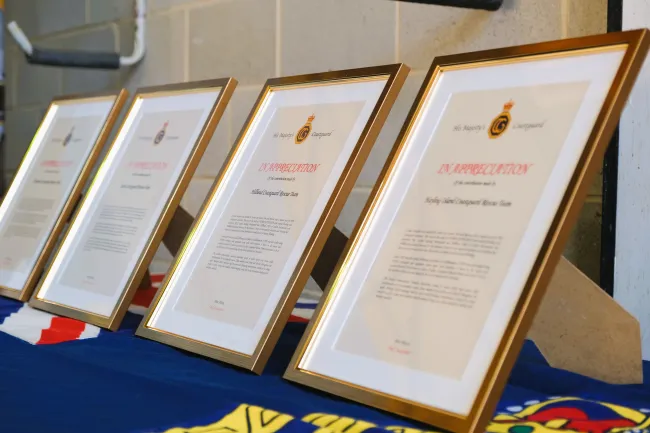 Framed awards of recognition lined up on a table