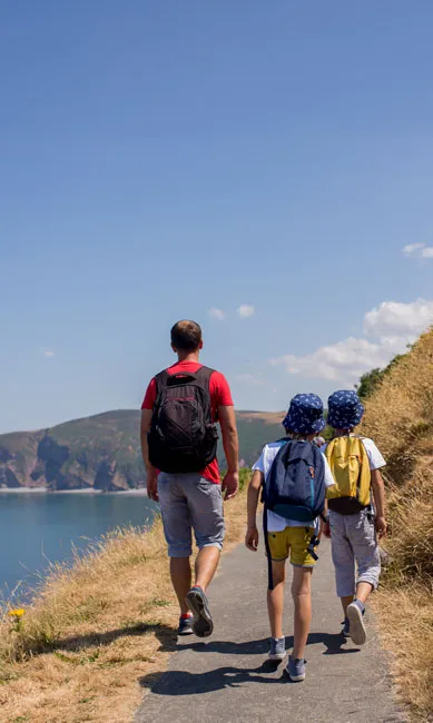 Family walking along coastal path in summer