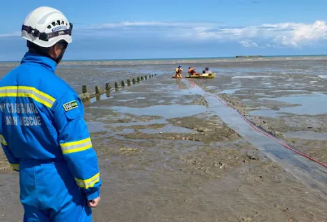A coastguard rescue officer looks on as the mud rescue takes place