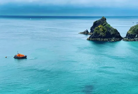 Mullion Coastguard Rescue Team and the RNLI helping when three people on a dinghy were struggling with the tide and offshore winds.