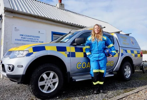 Coastguard rescue officer Kate Hannett next to a coastguard vehicle.