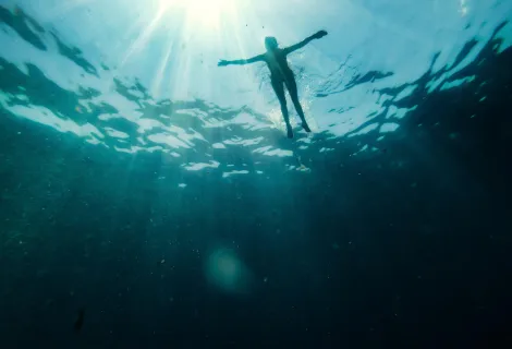 Float to live - a swimmer in the water with their arms spread out