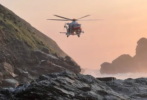 A Coastguard helicopter hovering at Bassets Cove, Portreath