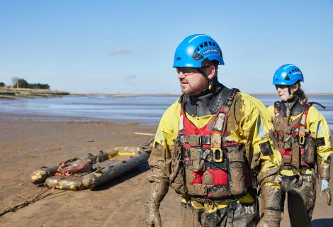 Two members of a coastguard mud rescue team 